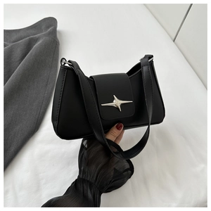 Détail de la boucle métallique étoile argentée sur un sac demi-lune en cuir synthétique noir