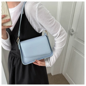 Detail of light blue rectangle shoulder bag with gold hardware and smooth matte PU leather