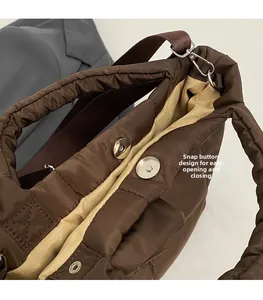 Close-up of quilted tote bag with magnetic closure and smooth beige fabric lining