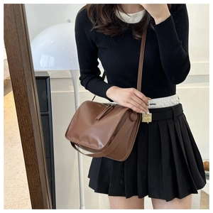 Mirror selfie showing the side view of a dark brown square leather shoulder bag with fringe