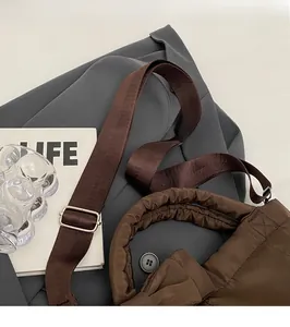 Detailed macro view of adjustable nylon strap and silver buckle on quilted shoulder bag