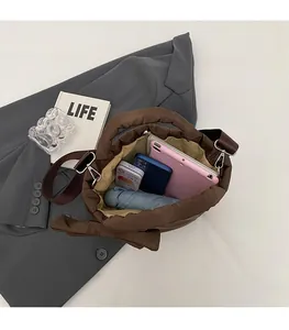Spacious interior of brown puffer tote bag showing capacity for tablet, phone, and umbrella