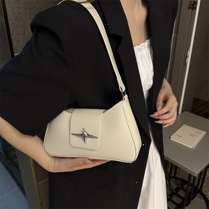 Borsa baguette minimalista bianco crema con fibbia a stella indossata a tracolla su modella