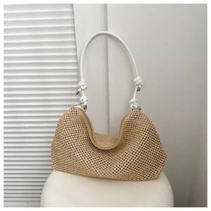 Dettaglio della borsa tote minimalista in paglia beige con spalline annodate bianche