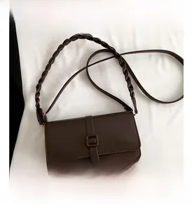 Dettaglio della piccola borsa a tracolla in pelle PU marrone scuro con manico intrecciato