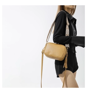 Brown pebbled leather crossbody bag with patterned woven strap and fringe detail