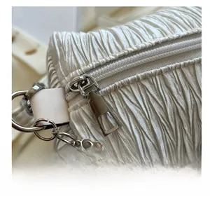 Macro view of white pleated fabric texture with silver zipper and decorative pearl chain