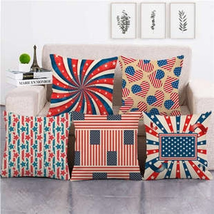 Detailed view of five linen pillowcases with American flag star and stripe patterns on a sofa