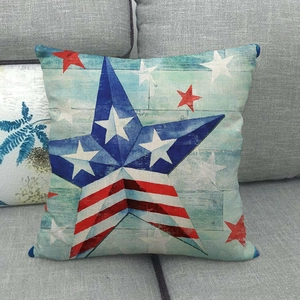 Linen pillow cover with American flag star design on a dark gray fabric sofa