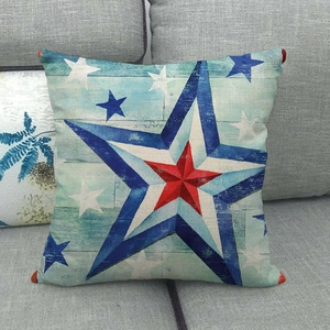 Detail of linen pillowcase with American star print and red decorative corner pom-poms
