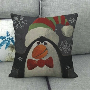 Detail of Christmas linen pillowcase featuring a cute penguin with a festive red hat and bow