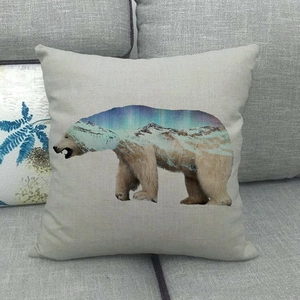 Detail of linen pillow cover featuring polar bear silhouette with aurora mountain print