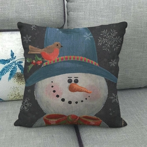 Close-up of a linen Christmas cushion with a cute snowman illustration on a sofa