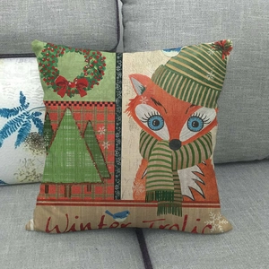 Detail of linen Christmas pillowcase with fox and tree pattern on gray sofa