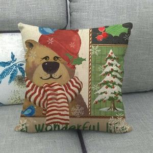 Linen Christmas pillowcase featuring a festive bear and tree pattern on a gray sofa