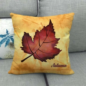 Dettaglio copricuscino in lino con foglia di acero rossa e scritta Autumn