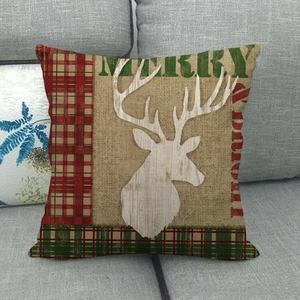 Detail of Christmas reindeer linen pillowcase with red and green plaid border on a sofa