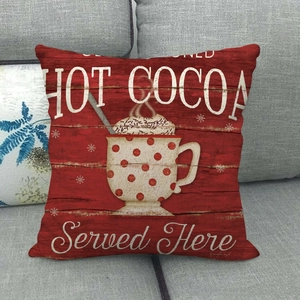 Detail of red Christmas pillowcase with Hot Cocoa print on a cozy grey fabric sofa