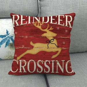 Macro view of Christmas reindeer cushion cover on a sofa with Reindeer Crossing text