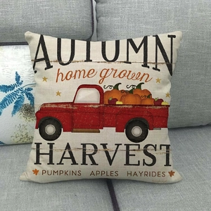 Detail of autumn harvest pillowcase with vintage red truck and pumpkin pattern on sofa