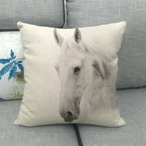 Cojín decorativo cuadrado con retrato de caballo en blanco y negro en sofá gris
