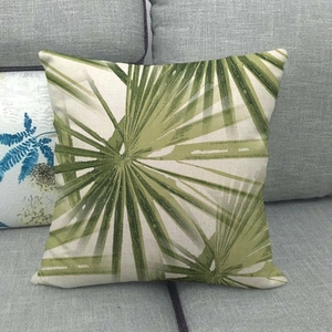 Detail view of tropical palm leaf print on textured beige linen throw pillow cover