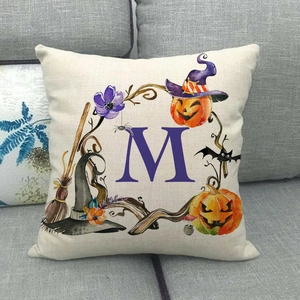 Dettaglio macro della federa di Halloween con lettera M ad acquerello e decori di zucca