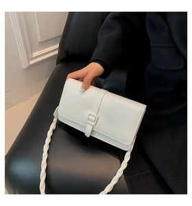 Dettaglio borsa a tracolla bianca in pelle liscia con spallina intrecciata decorativa