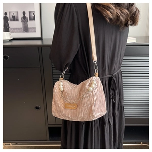 Detail of pink pleated crossbody bag with large pearl chain and fashion label