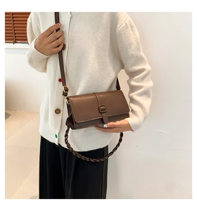 Borsa a tracolla vintage in pelle marrone con tracolla intrecciata, indossata dal modello