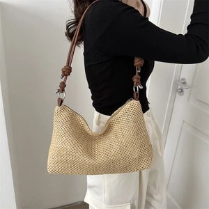 Borsa a spalla in paglia intrecciata bohémien con tracolla in pelle marrone su modella