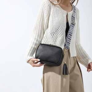 Fashionable black pebbled square crossbody bag with geometric wide strap and tassel detail