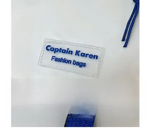 Close-up of waterproof white fabric texture and blue woven strap with brand label