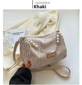 Detail of khaki nylon bag with pearl chain and metallic flower accents