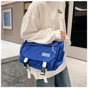 Detail view of Klein blue messenger bag with dual white buckles and adjustable shoulder strap