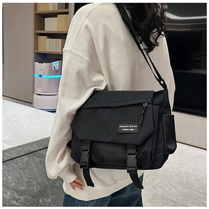 Rear view of a minimalist black large capacity crossbody messenger bag on a male model