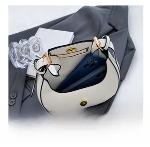 Detailed interior view of white crescent hobo bag showing space for two smartphones