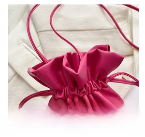 Detail of magenta bucket bag featuring lychee texture and drawstring closure