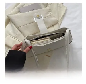 Interior view showing large storage capacity of the white minimalist leather shoulder bag
