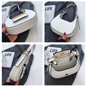 Detailed views of a white minimalist half-moon handbag with gold buckle and black trim