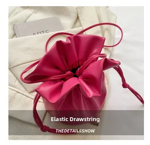 Detailed view of the hot pink bucket bag with drawstring closure and soft leather texture