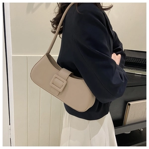 Détail d'un sac sous le bras beige minimaliste doté d'une élégante boucle carrée