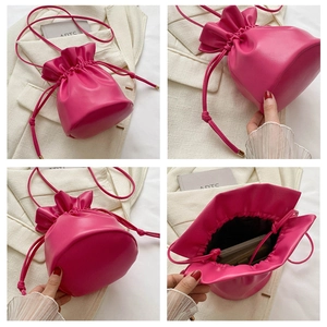 Detail of rose red drawstring bucket bag showing circular base and internal storage space