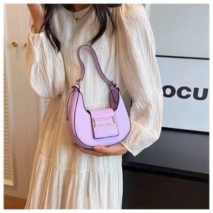 Close-up of light purple crescent shoulder bag with a gold geometric clasp and black edging