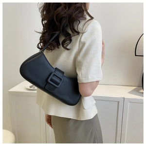 Vue latérale d'un sac sous le bras chic en cuir noir avec boucle carrée sur modèle