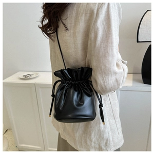 Classic black bucket bag with drawstring closure shown on model for daily commute style