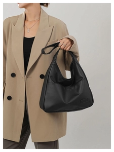 Chic black PU leather hobo tote bag styled with a khaki blazer for an elegant minimalist look