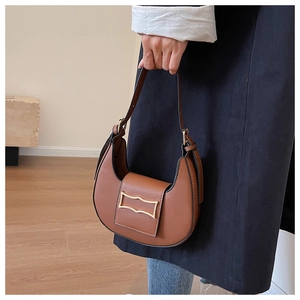 Detail of vintage brown leather hobo bag with a gold geometric clasp and sleek crescent shape
