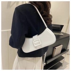 Detail view of the white crescent shoulder bag showing smooth matte leather texture
