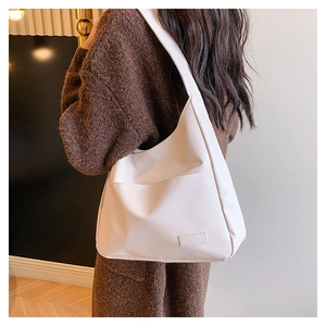Detail of minimalist cream large tote bag with front pocket and faux leather texture